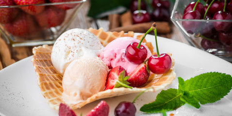 Banana split sundae ice cream in a bowl with strawberry and raspberry vanilla icecream scoops