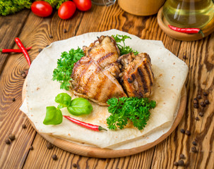 Grilled chicken with sauce on a wooden table