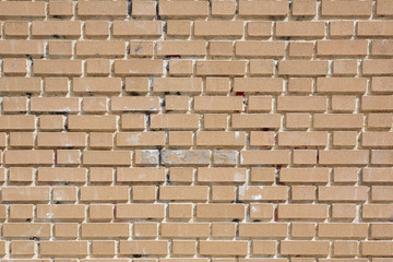 Beige weathered bricks wall in sunlight, texture background
