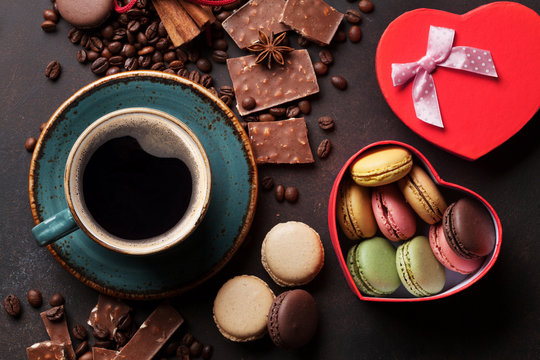 Coffee, chocolate and macaroons on old kitchen table