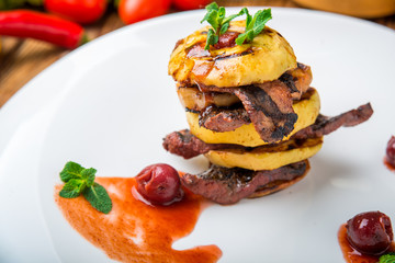 baked apples and grilled meat on the plate