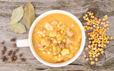Split pea soup, decorated with some bay leaves, marjoram and peas