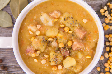 Split pea soup, decorated with some bay leaves, marjoram and peas