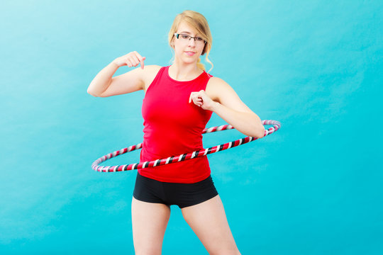 Fit woman with hula hoop doing exercise