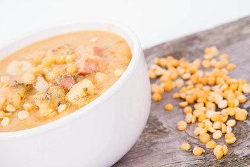Split pea soup, decorated with some bay leaves, marjoram and peas