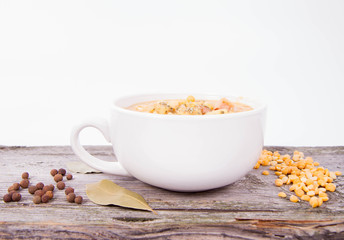 Split pea soup, decorated with some bay leaves, marjoram and peas
