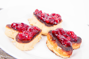 Heart shaped pancakes with cowberry jam