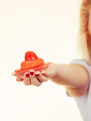 Woman hand holding sweet strawberry cupcake