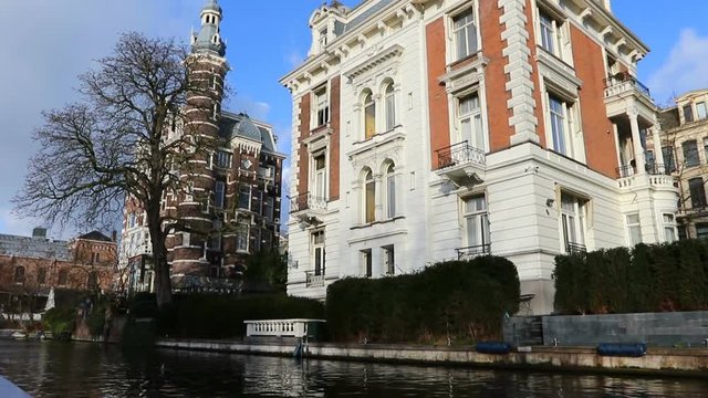 Amsterdam, Netherlands - January 03: Slow motion video of view from the canal to the streets, canals with old flamish houses and bridges in Amsterdam, Netherlands.