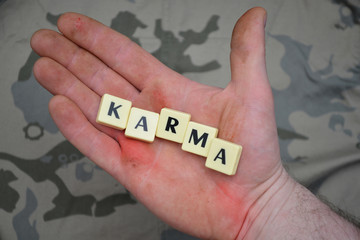 letters with text karma on a dirty hand. concept
