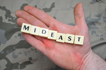 letters with text mideast on a dirty hand. concept