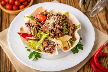 Doner kebab - fried chicken meat with vegetables in pita bread