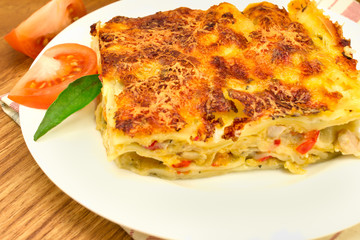 a plate of lasagna on a striped napkin