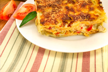 a plate of lasagna on a striped napkin