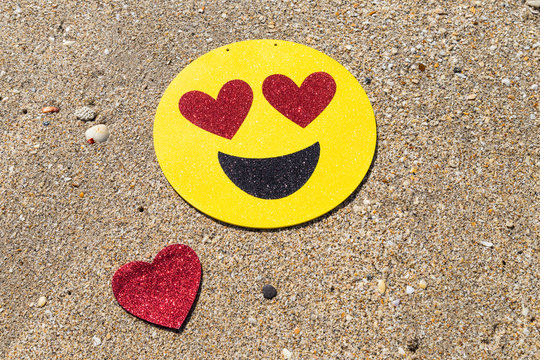 Happy love smile/Glitter heart eyes smiley sign and red glitter heart on the tropical beach