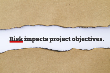 Fototapeta na wymiar RISK impacts project objectives message written under torn paper.