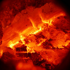 Texture of burning wood charcoal and flames close up