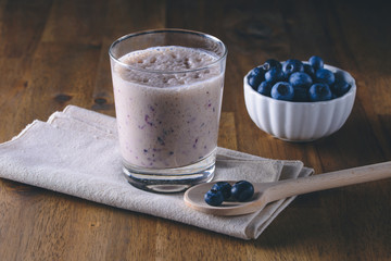Blueberry yogurt with fresh blueberries on rustic wooden background