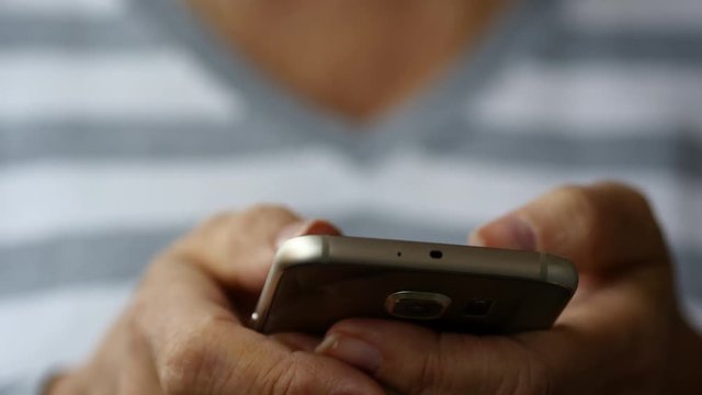 Elderly Woman Typing Email On Smartphone, White Background, Close Up