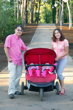 Young Parents And Their Two Little Children In A Twin Stroller