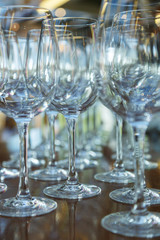 Clean glasses on a table prepared by the bartender for champagne and wine.