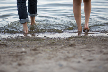 lovers playing in the water with their feet