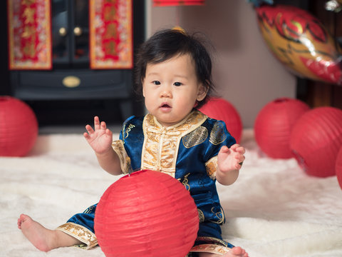 Asian baby girl playing with Chinese new year greeting decoratio