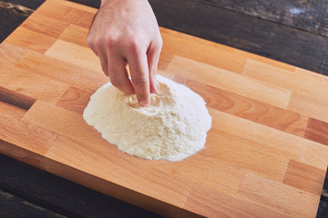 Male hand preparing flour on table