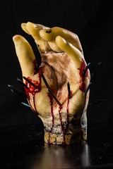 wax hand sculpture with nails and blood