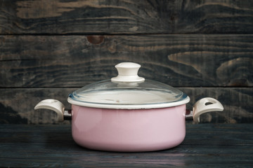 Vintage Style Pink Enamel Saucepan on Blue Wooden Background