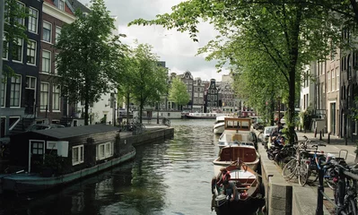 Fotobehang Netherlands, Amsterdam. Types of cities, buildings, canals and boats. Views on the water background. Amsterdam in the spring. © Денис Куров