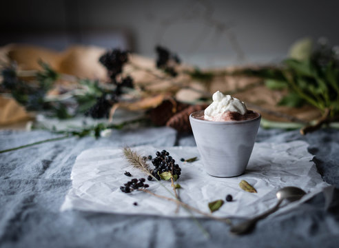 Hot chocolate in glass on linen tablecloth with flowers