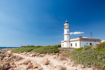 Fototapeta na wymiar Lighthouse at Cap de Ses Salines. Mallorca island, Spain.This lighthouse is located at the southernmost point of Mallorca.