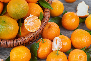 Fresh tangerines with leaves on a wooden table