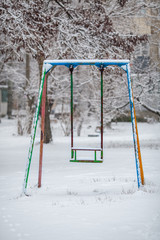 empty metal swing in winter