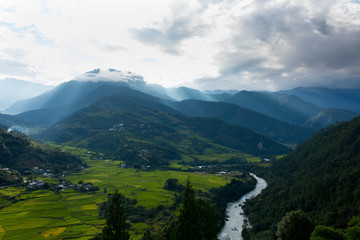 Bhutan Punakha valley hill and mountains landscape with a river beautiful rice fields at sunset