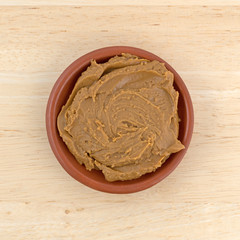 Cookie butter in a small bowl on a wood table top view.