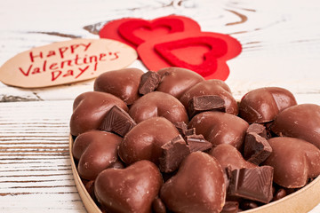 Heart-shaped chocolates in box. Card, red hearts and candies. Love is the answer.