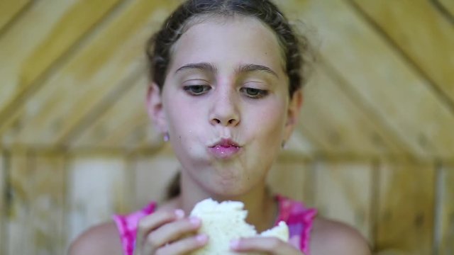 Hungry girl eats bread. Pretty girl eats slice of white bread