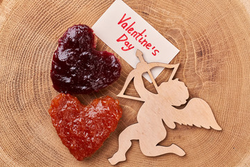 Heart-shaped toast with jam. Valentine's Day card near Cupid. Delicious romantic breakfast for beloved.