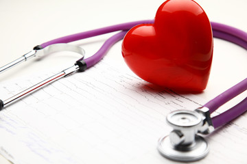 Heart with a stethoscope, isolated on wooden background