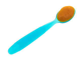 Baby food on a blue spoon top view isolated on a white background.