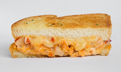 A cheese, prawn, seafood and tomato grilled sandwich, isolated on a white background