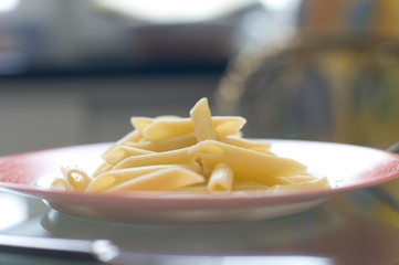 Penne pasta on red plate