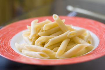 Penne pasta on red plate