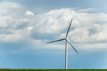 Fototapeta premium windmill for electric power prodaction on rural floral field 
