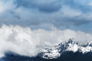 beautiful mountain high covered with snow under the blue cloudy sky