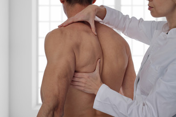 Chiropractic, osteopathy, manual therapy, acupressure. Therapist doing healing treatment on man's back. Alternative medicine, pain relief concept