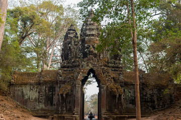 Cambodia Angkor Wat ancient stone arch with tuk tuk driver