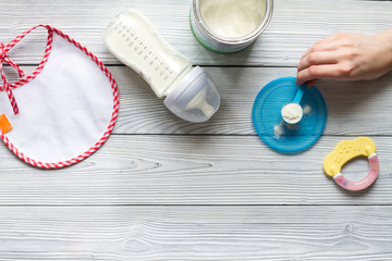 preparation of mixture baby feeding on wooden background top view